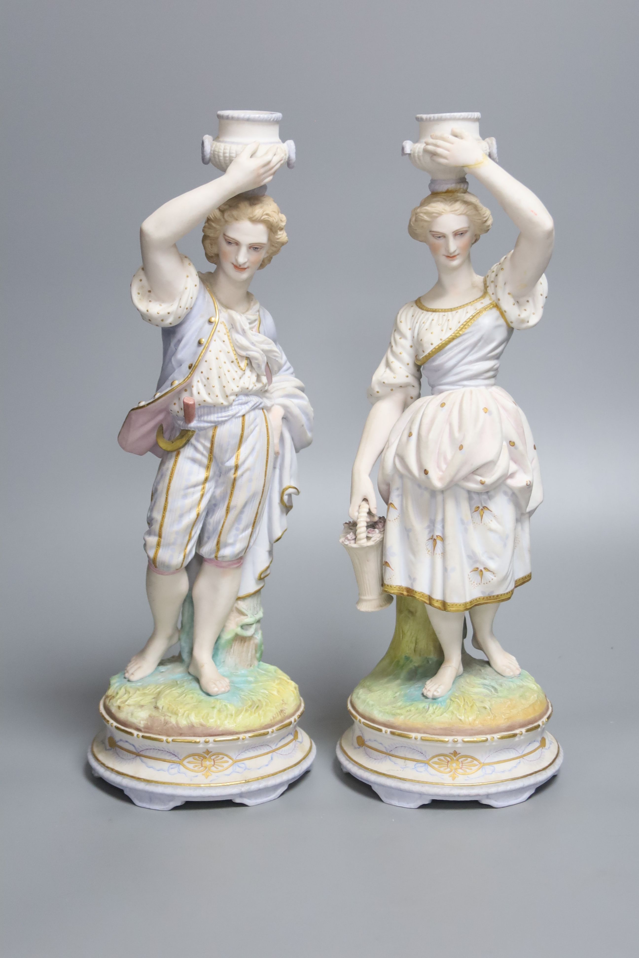 A pair of French export bisque porcelain figural candlesticks, stamped Chantilly, height 34cm (one damaged)